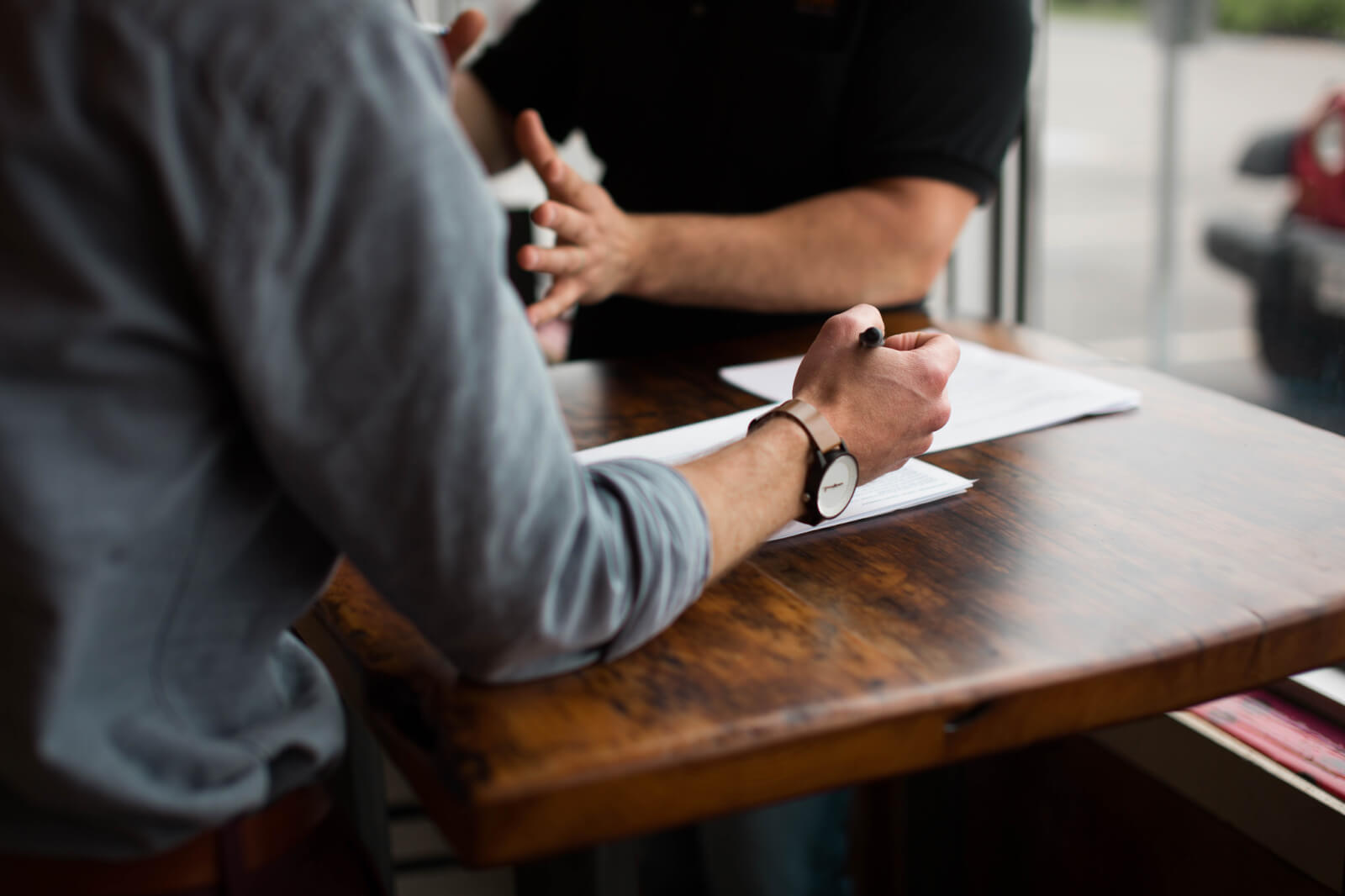 A contractor and a marketer talking through a plan across a table